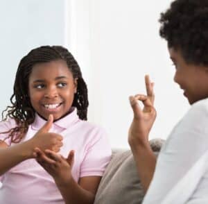 Deaf girl talking in sign language with carer