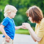 foster mum comforting young boy who has hurt his hand