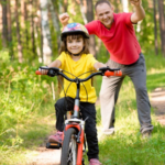 foster dad and daughter learning to ride bike safely - celebrating