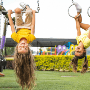 children playing on playground equipment hanging upside down