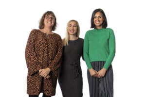 three female social workers with the foster care charity smiling and welcoming prospective foster carers