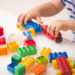 Young child playing with lego tractor safely - beware small pieces choking hazard