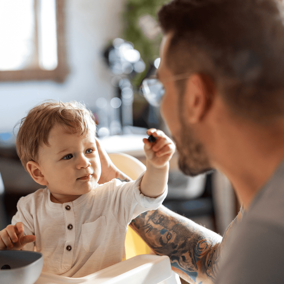 Dad and baby boy learning to eat PACT parent and child fostering