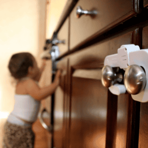 kitchen cupboards with child proof locks - toddler in the background