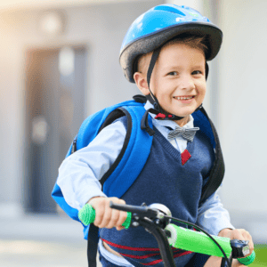 Boy wearing bicycle helmet dressed in school clothes - safe cycling