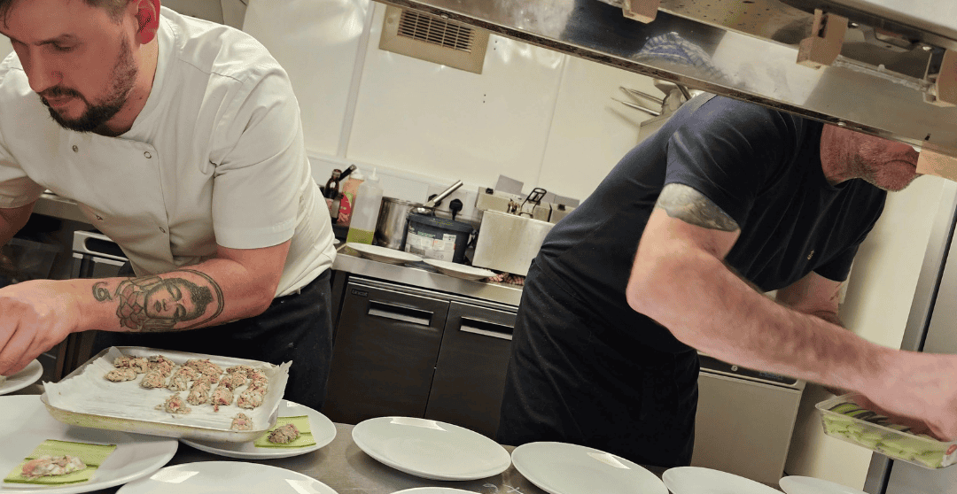 Michael patron of The Foster Care Charity dishing up meals at his bistro with assistant chef